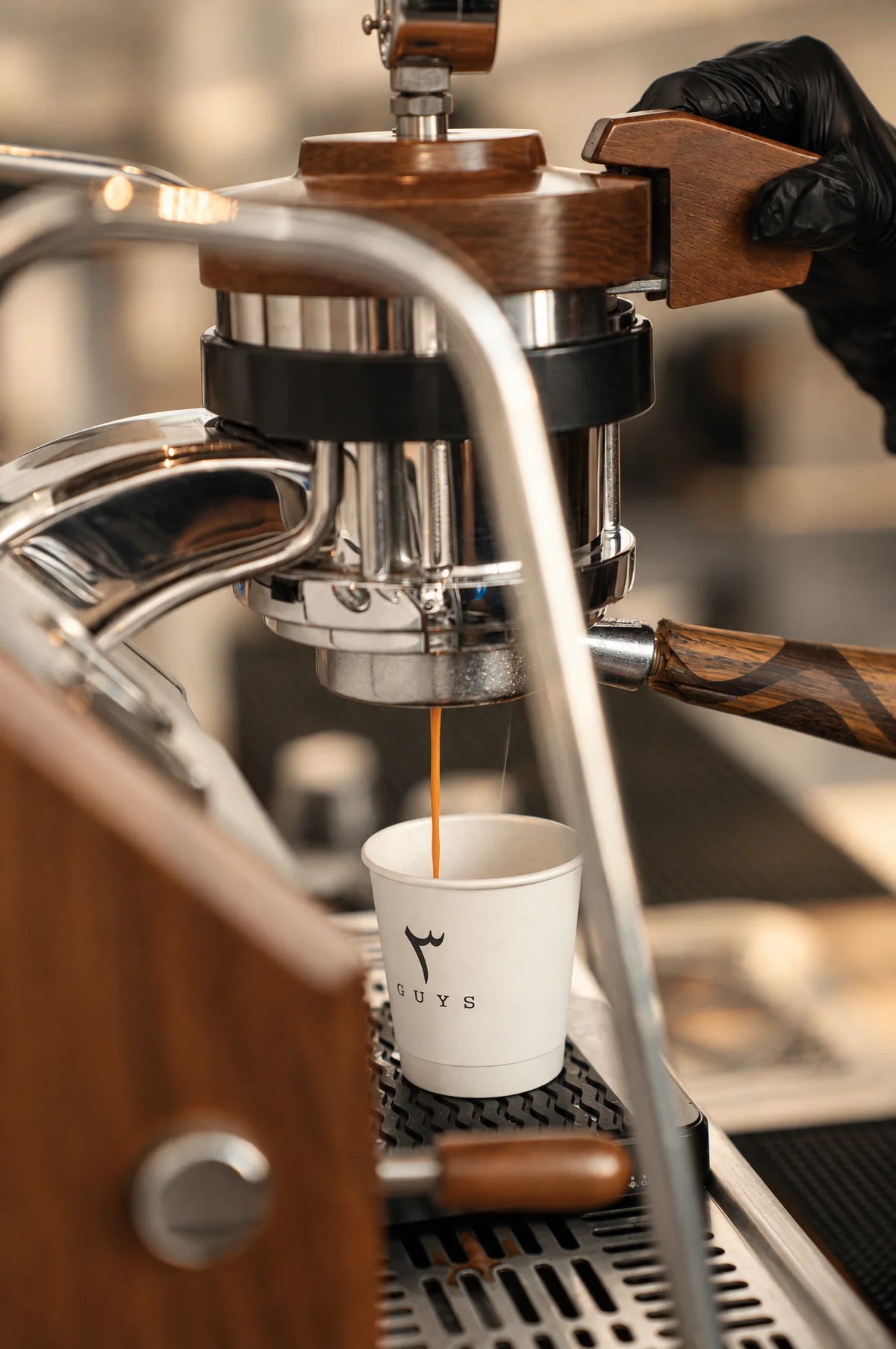 Espresso running from the portafilter into a 3 Guys cup.