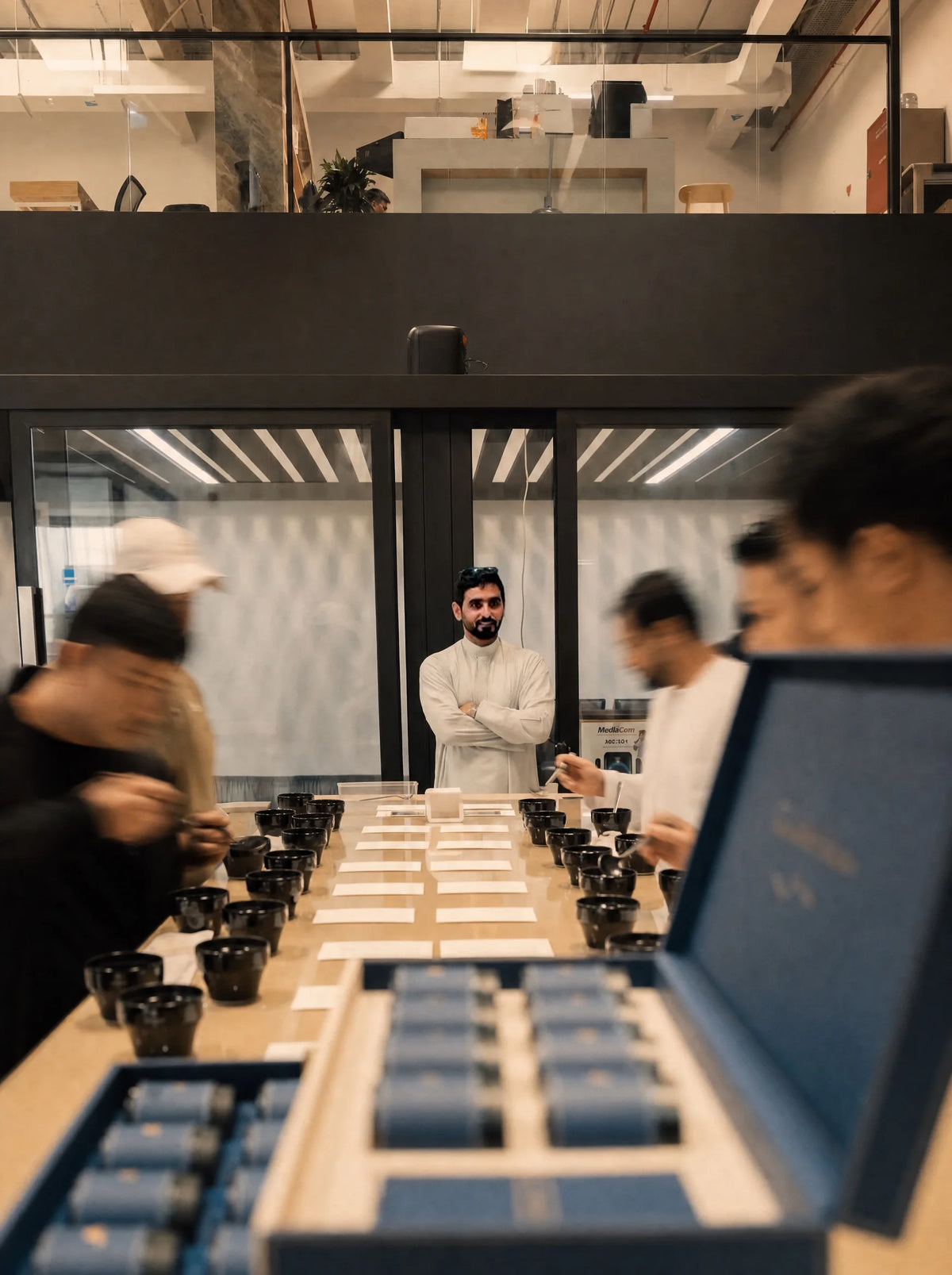 A cupping table: rows of cupping bowls and tasters with spoons.